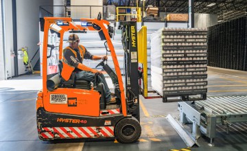 Ein Mann in einem Gabelstapler in einem Warenlager